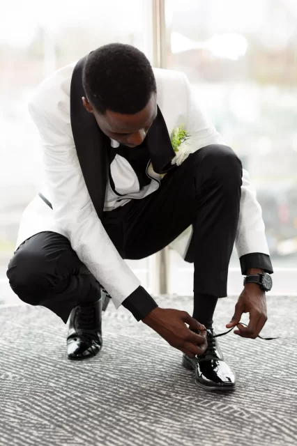 a groom tieing his shoe laces